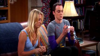 Kaley Cuoco sporting some pokey nipples in a white tank top as she answers an apartment door and chats with a guy. From The Big Bang Theory.